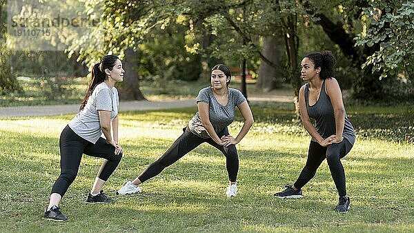 Drei Freundinnen trainieren im Park
