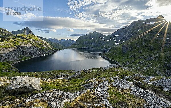 Berglandschaft mit See Tennesvatnet  bei Sonnenaufgang mit Sonnenstern  Moskenesøya  Lofoten  Nordland  Norwegen  Europa