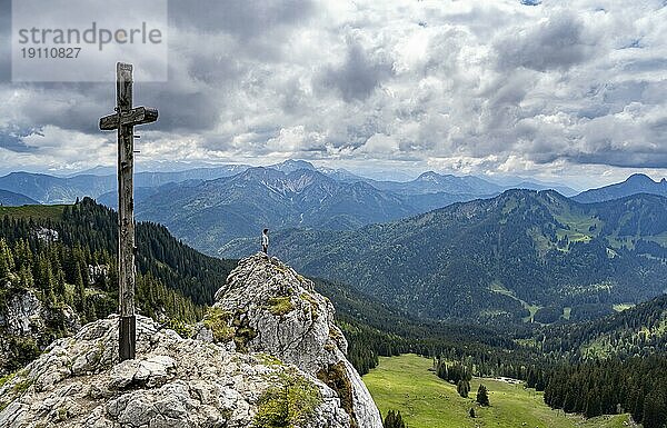 Bergsteigerin am Gipfel des Taubenstein mit Gipfelkreuz  Mangfallgebirge  Bayern  Deutschland  Europa