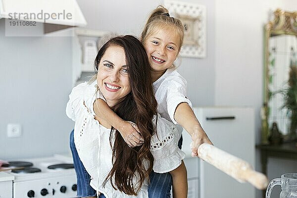 Glückliche Mutter Tochter posiert mit Küchenrolle