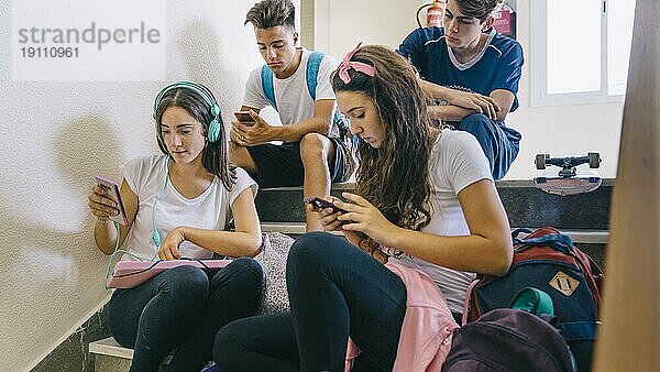 Gruppe von Schulkindern auf der Suche nach Smartphones
