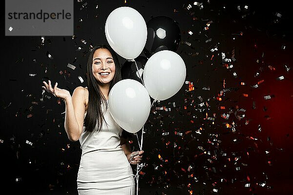 Lächelnde Frau posiert mit Luftballons Neujahrsparty