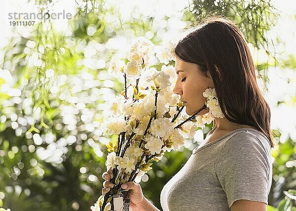Frau riecht an weißen Blumen