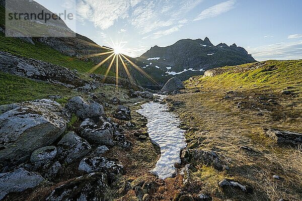 Berglandschaft bei Sonnenaufgang mit Sonnenstern  Moskenesøya  Lofoten  Nordland  Norwegen  Europa