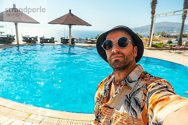 Tourist Mann im Hotelpool im Sommer ein Selfie genießen den Urlaub nehmen