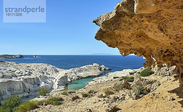 Berühmte weiße Felsen von Sarakiniko Strand  Ägäisches Meer  Insel Milos  Griechenland. Leere Klippen  Sommertag Sonne  klares Meer  blaues Wasser  azurblaue Lagune  große orangefarbene Felsen  ein Erwachsener geht schwimmen  schöne Landschaft  fantastisches Reiseziel