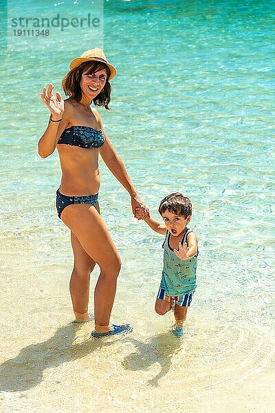 Mutter und Sohn im Sommer am Strand von Paralia Mikros Gialos im Süden der Insel Lefkada. Griechenland