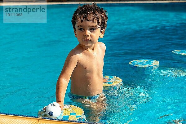 Porträt eines zweijährigen Jungen im Schwimmbad  der die Sommerferien genießt