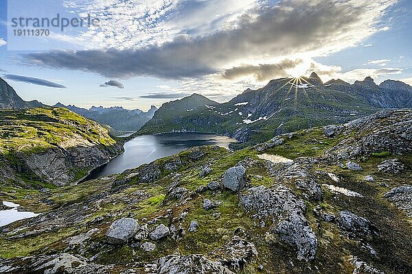 Berglandschaft mit See Tennesvatnet  bei Sonnenaufgang mit Sonnenstern  Moskenesøya  Lofoten  Nordland  Norwegen  Europa