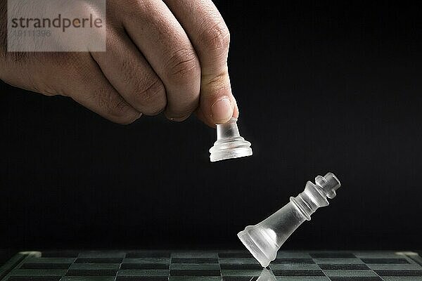 Hand bewegt transparente Schachfiguren