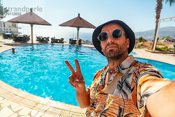 Tourist Mann im Hotelpool im Sommer ein Selfie genießen den Urlaub nehmen