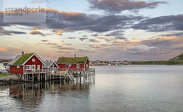 Traditionelle rote Rorbuer Hütten am Wasser bei Sonnenuntergang  Reine  Lofoten  Nordland  Norwegen  Europa