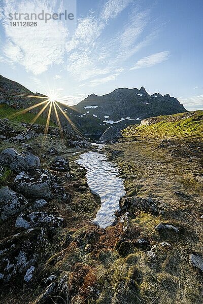 Berglandschaft bei Sonnenaufgang mit Sonnenstern  Moskenesøya  Lofoten  Nordland  Norwegen  Europa