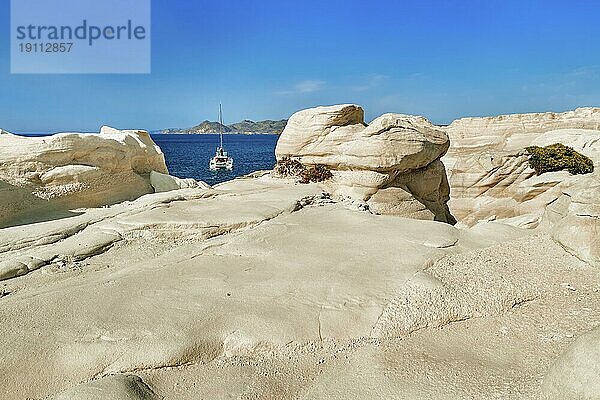 Berühmte weiße Felsen von Sarakiniko Strand  Ägäisches Meer  Insel Milos  Griechenland. Keine Menschen  einsames Segelboot  leere Klippen  Sommertag Sonnenschein  klares Meer  blaues Wasser  keine Wolken Himmel  schöne Landschaft  fantastische Felsen von Touristenziel