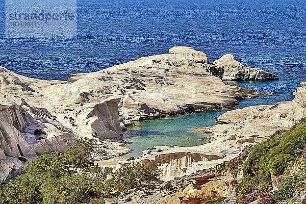 Berühmte weiße Felsen am Strand von Sarakiniko  Ägäisches Meer  Insel Milos  Griechenland. Wenige Touristen verstecken sich im Schatten  leere Klippen  Sommertag Sonnenschein  klares Meer  blaues Wasser  schöne Landschaft  fantastische Felsen von Touristenziel