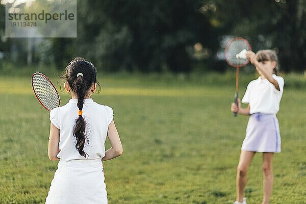 Rückansicht Mädchen spielt Badminton mit ihrer Freundin