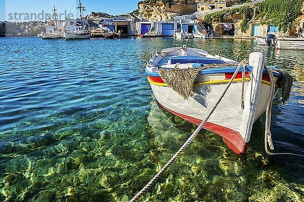 Bunte authentische griechische Fischerboote vor Anker in einem kleinen Dorf in kristallklarem Wasser. Sommertag Sonnenschein  Insel  weiß getünchten Boot Häuser  Mittelmeer Urlaub  Reiseziele. Selektiver Fokus  unscharfer Hintergrund. Milos  Griechenland  Europa