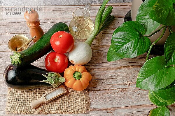 Draufsicht auf eine Gruppe frischer Gemüsesorten zur Zubereitung eines vegetarischen Menüs  Paprika  Zwiebel  Tomate  Aubergine  Zucchini  Olivenöl  Eierpflanze