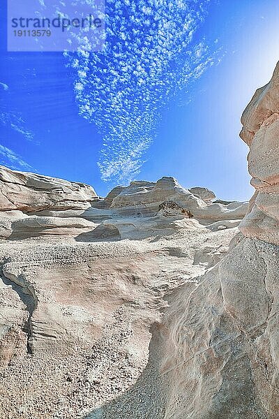 Schöne weiße Felsen von Sarakiniko Strand  Ägäisches Meer  Insel Milos  Griechenland. Keine Menschen  leere Klippen  Sommertag Sonne  Mondlandschaft  fantastische Felsen von Touristenziel  tiefblauer Himmel  Wolken  vertikale Schuss