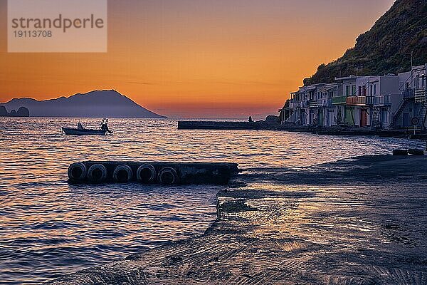 Schöner Blick auf den Sonnenuntergang im Dorf Klima  Insel Milos  Griechenland. Single Erwachsenen genießen Sonnenuntergang Blick auf Pier des kleinen Fischerdorfes. Bunte Häuser  am Wasser  in der Ferne dunstigen Bergen  ruhiges Meer  klaren Himmel  romantisches Wochenende  entspannen  Urlaub  Reise