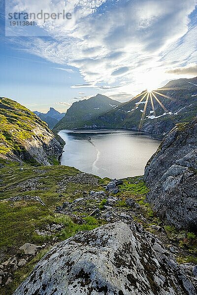 Berglandschaft mit See Tennesvatnet  bei Sonnenaufgang mit Sonnenstern  Moskenesøya  Lofoten  Nordland  Norwegen  Europa