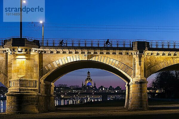 Albertbrücke mit Radfahrer und Frauenkirche mit der Glaskuppel über dem Oktogon der Kunstakademie  diese ist aus Protest gegen den Ukraine Krieg  blau beleuchtet