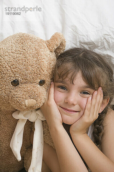 Nahaufnahme eines jungen Mädchens mit lächelndem Teddybär