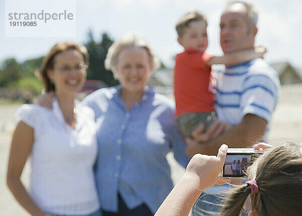 Rückansicht eines jungen Mädchens  das ein Foto ihrer Familie macht