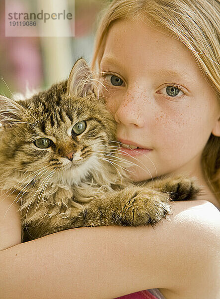 Nahaufnahme eines jungen Mädchens  das ein Kätzchen umarmt