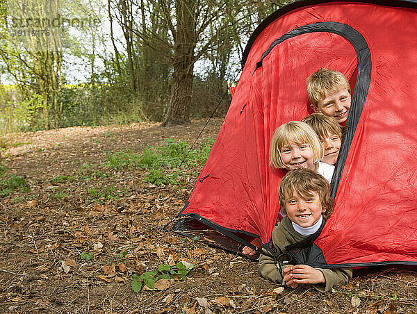 Portrait of children coming out of tent opening