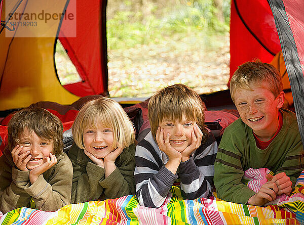 Porträt von Kindern  die in einem Zelt liegen