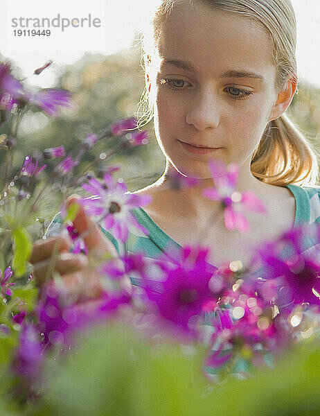 Nahaufnahme eines jungen Mädchens  das Blumen bewundert