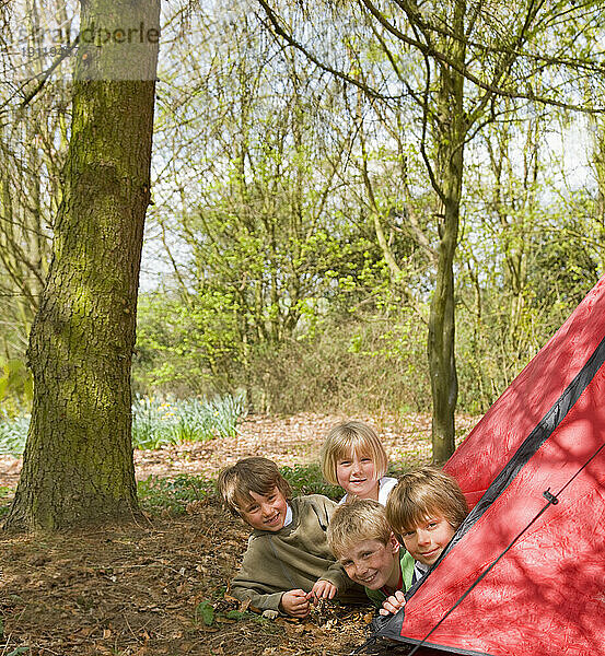 Portrait of children coming out of tent opening