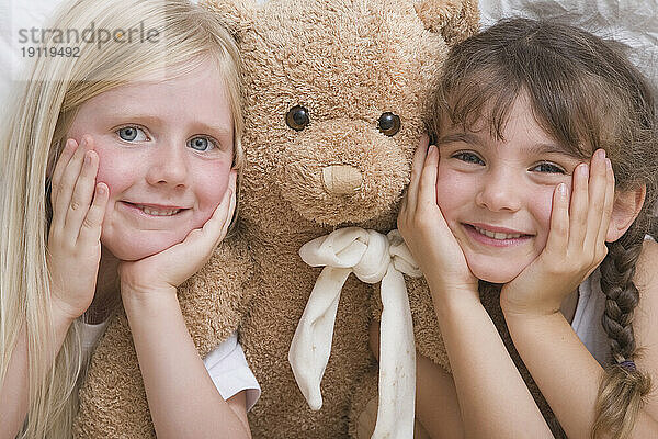 Nahaufnahme von zwei jungen Mädchen mit lächelndem Teddybär