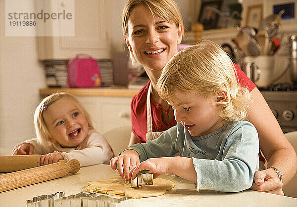 Portrait of young blonde woman with little girls smiling and baking