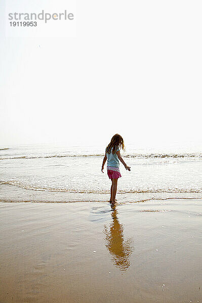Junges Mädchen spielt am Strand