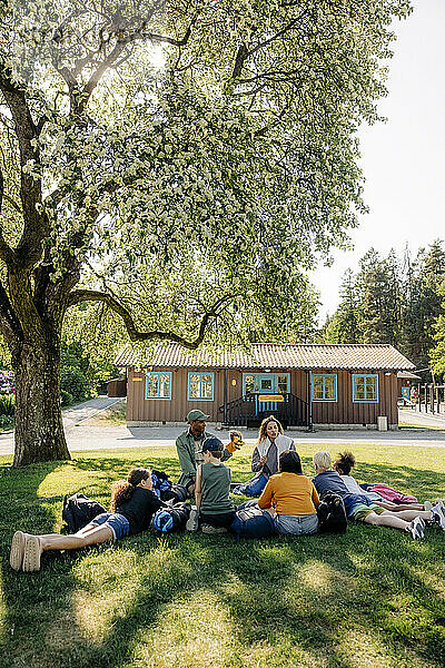 Betreuer bei Aktivitäten mit Kindern  die im Sommercamp im Gras liegen