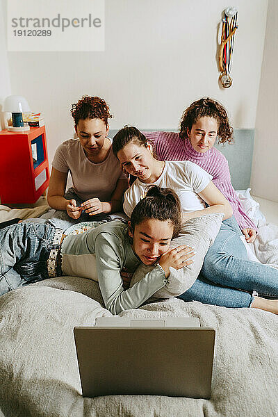 Freundinnen sehen sich zu Hause gemeinsam einen Film auf dem Laptop an