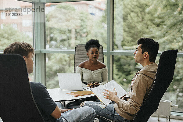 Multirassische Studenten diskutieren beim gemeinsamen Studium an der Universität