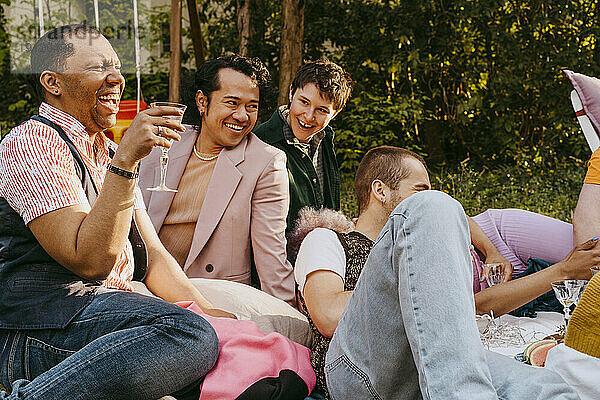 Fröhliche Freunde aus der LGBTQ-Gemeinschaft haben Spaß bei einer Party im Hinterhof