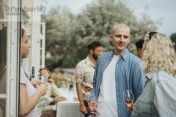 Männliche und weibliche Freunde genießen Wein während einer Dinnerparty im Café