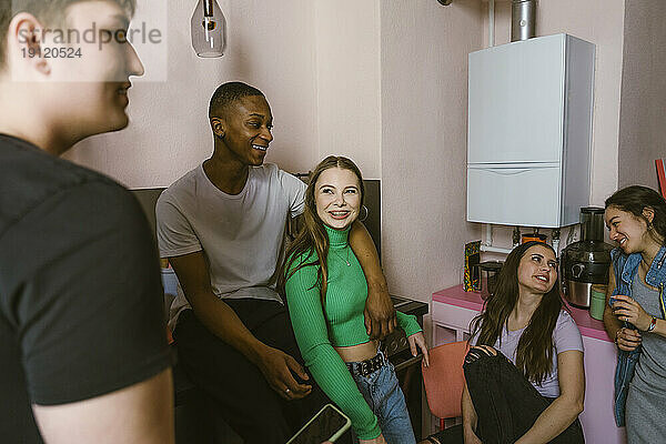 Glückliche junge gemischtrassige Freunde genießen in der Küche zu Hause