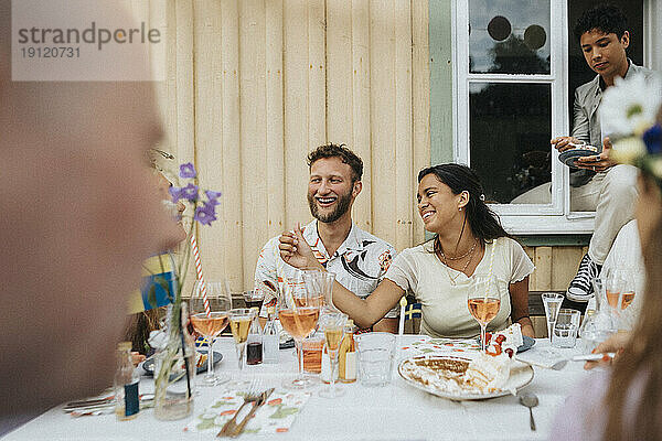 Mann und Frau genießen mit Freunden während des Abendessens Partei beim Sitzen im Café Tisch