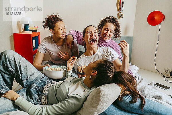 Weibliche Freunde haben Spaß und genießen Snacks zu Hause
