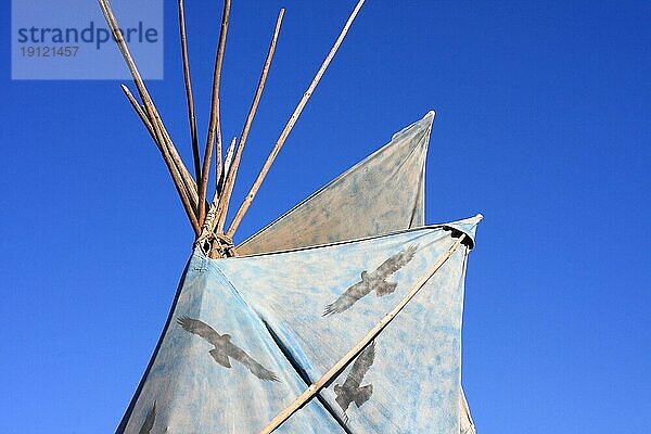 Hellblaues Indianerzelt mit einem Muster aus schwarzen Vögeln  Hintergrund strahlend blaür Himmel