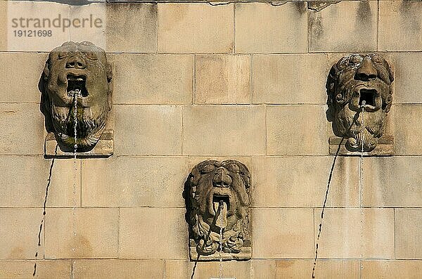 Drei verschiedene Wasserspeier in Fratzenform an einer gemauerten Wand in Luxemburg