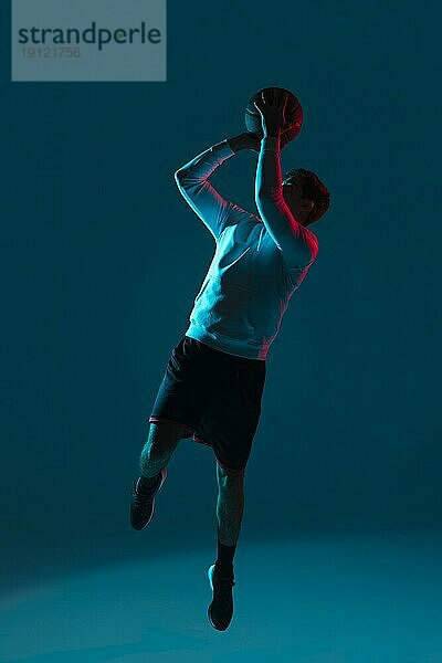 Mann spielt Basketball mit kühlen Lichtern