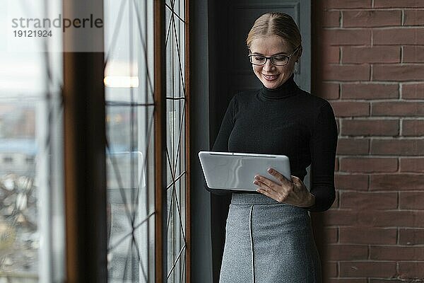 Schöne junge Frau mit Tablette