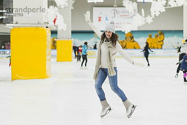 Fröhliche Frau auf der Eisbahn