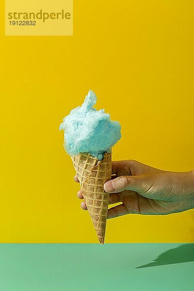 Vorderansicht Hand hält Eistüte mit Zuckerwatte